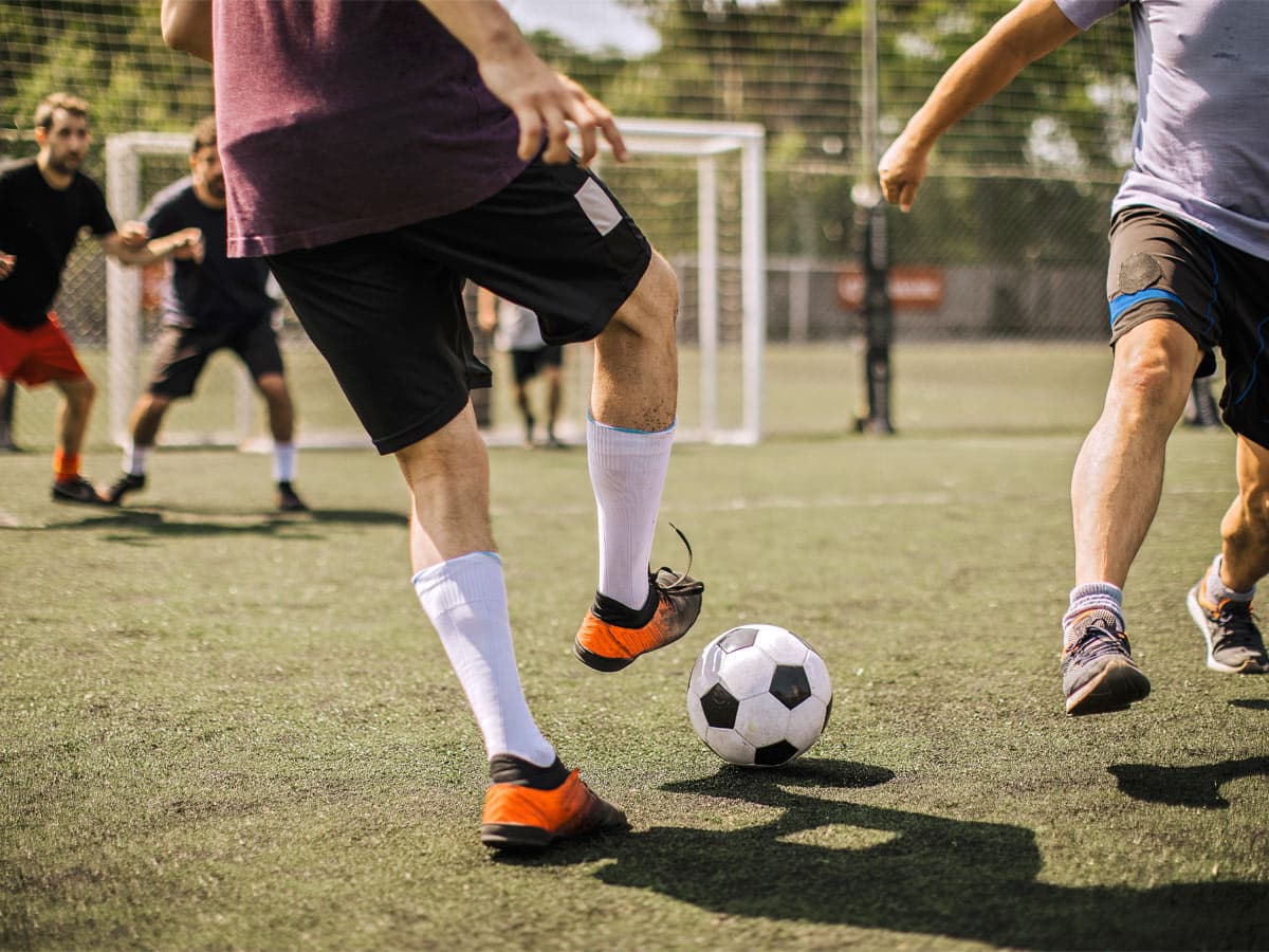 Dzīvs futbolspēle norisinās, ar dažāda kabata spēlētājiem uz labi uzturēta laukuma
